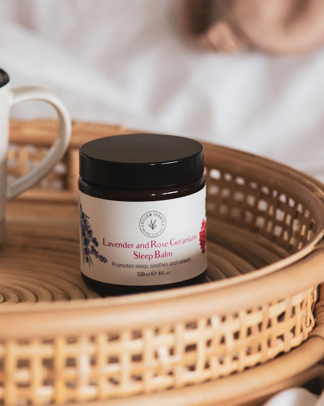 A lavender and rose geranium sleep balm on a wicker tray