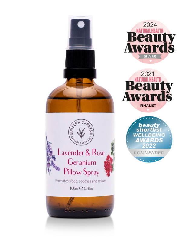 Bottle of Lavender & Rose Geranium Pillow Spray with awards on a white background