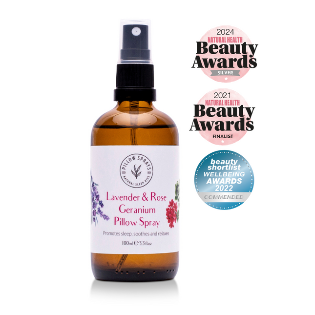 Bottle of Lavender & Rose Geranium Pillow Spray with awards on a white background