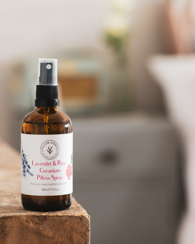 A Lavender and Rose Geranium Pillow Spray in an amber glass bottle on a shelf