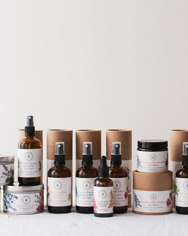 A range of natural sleep aids including pillow sprays, a night oil, a sleep balm, and candles